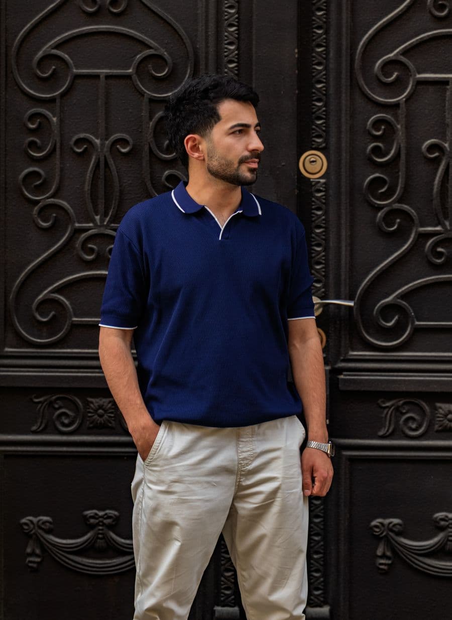 Man in a navy polo shirt and stone chinos