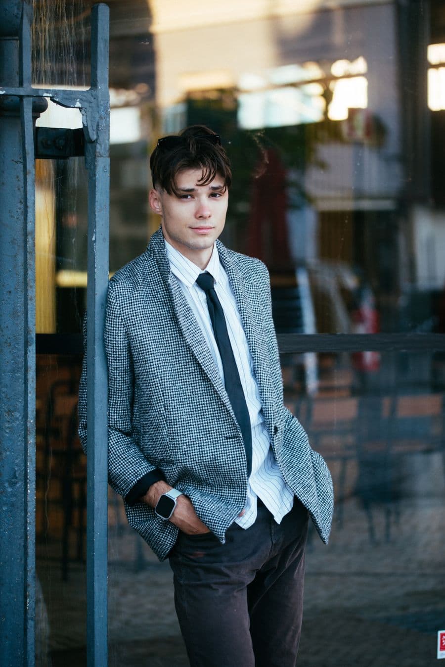 Man in a grey check sport coat and tie