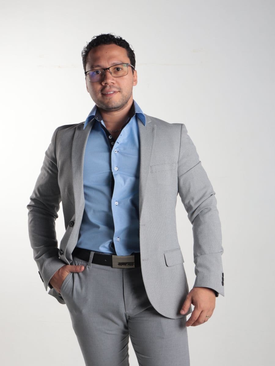 Man in a light grey suit and light blue shirt, no tie