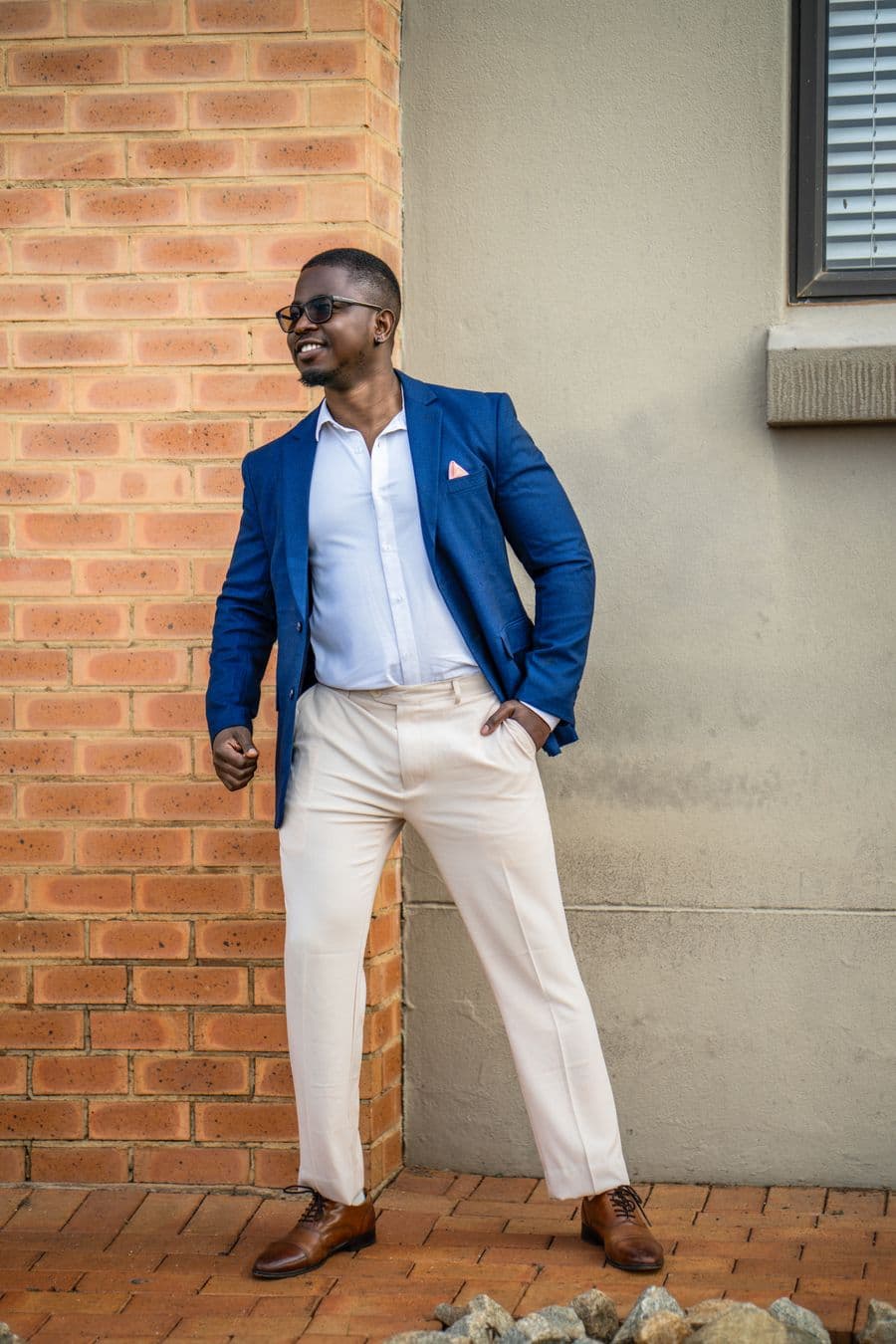 Man in a navy blazer, white shirt and cream chinos